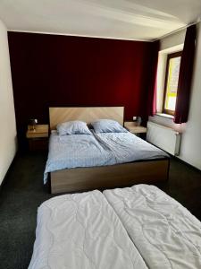 a bedroom with two beds and a red wall at Neros Hotel in Siegenburg