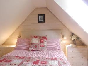 a bed with pillows on it in a attic at Kathleen's Croft, charming detached croft house in Torridon +4 photos