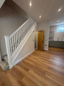an empty living room with stairs and a kitchen at Windsor Flat 90A in Windsor +7 photos
