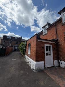 a brick building with a white door on a street at Windsor Flat 90A in Windsor