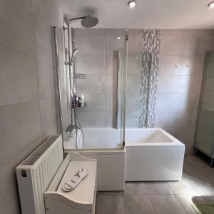 a white bathroom with a tub and a shower at Spacious King En Suite in St. Albans