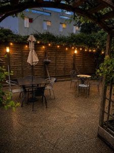 a patio with a table and chairs and lights at The Beaumont in Sittingbourne