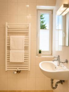 a bathroom with a sink and a window and a towel at Hotel Pension Vineta Rügen in Baabe +20 photos