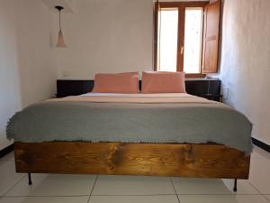 a bedroom with a wooden bed with two pink pillows at MontalciNest in Montalcino