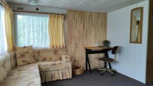 a living room with a couch and a desk and a window at Medumi Lake in Medumi