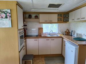 a small kitchen with white cabinets and a sink at Medumi Lake in Medumi +48 photos