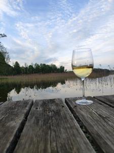 a glass of wine sitting on a table next to a lake at Medumi Lake in Medumi