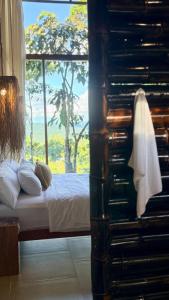 a bedroom with a bed and a large window at Wild Wasi - Private Jungle Villa in Puyo