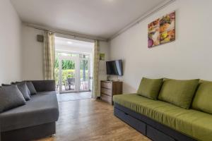 a living room with a couch and a television at Zamárdi Parti Apartman in Zamárdi