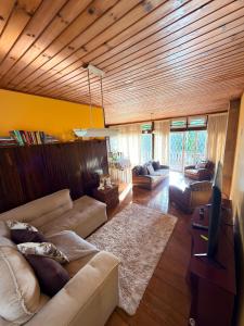 a living room with a couch and a tv at Recanto MJ in Campos do Jordão