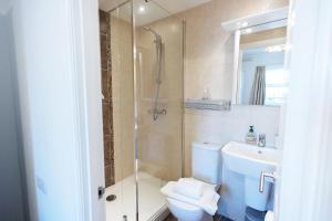 a bathroom with a shower and a toilet and a sink at Harbour Penthouse Whitby in Whitby +24 photos
