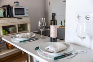 a table with two plates and a bottle of wine and glasses at Mourisco Guest House in Alijó
