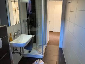 a bathroom with a sink and a glass shower at Kiek mol wedder in in Borkum