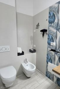 a white bathroom with a toilet and a sink at Sienda Cesira in Muravera