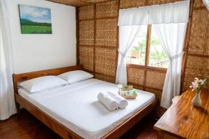 a bedroom with a bed with towels on it at D Mountain Beach Resort - Beachfront in Puerto Galera