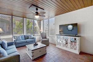 a living room with a couch and a flat screen tv at Beachhead Unit 5 BH5 in Port Aransas
