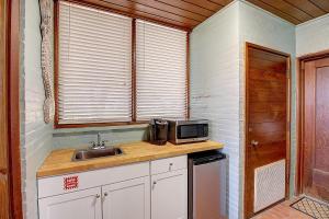 a kitchen with a sink and a microwave at Beachhead Unit 5 BH5 in Port Aransas