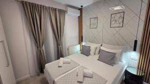 a bedroom with a large white bed with gray pillows at Villa Rossa in Tučepi