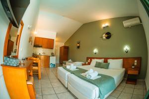 ein Schlafzimmer mit einem großen Bett und eine Küche in der Unterkunft Melitsa Corfu Hotel in Sidari + 87 Fotos