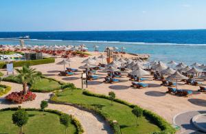 a beach with umbrellas and chairs and the ocean at Charmillion Sea Life Resort in Sharm El Sheikh +42 photos