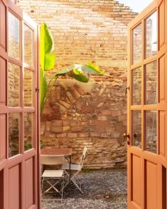 an open door with a table and a chair in front of a brick wall at Cordoba Calle Pozanco in Córdoba