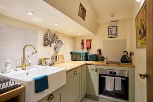 a kitchen with a sink and a stove at The Apartment at Charles Road in Frome