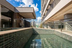 a swimming pool on the side of a building at Apts in a Building with Pool and Gym - GRL in Anápolis