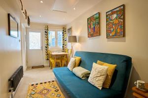 a blue couch in a living room with a table at The Apartment at Charles Road in Frome