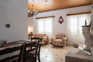 a living room with a table and chairs and windows at Sofia's Sea View House in Ágios Dimítrios +25 photos