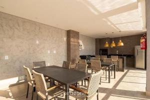 a dining room with tables and chairs and a kitchen at Apts in a Building with Pool and Gym - GRL in Anápolis