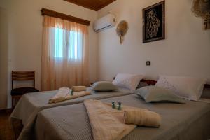 a bedroom with two beds with towels on them at Sofia's Sea View House in Ágios Dimítrios
