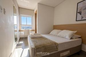 a bedroom with a bed and a large window at Apts in a Building with Pool and Gym - GRL in Anápolis +165 photos