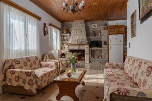 a living room with two couches and a table at Sofia's Sea View House in Ágios Dimítrios