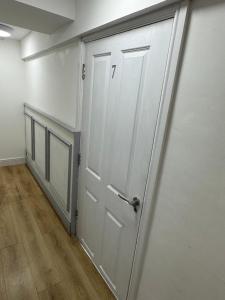 a white door in a room with a wooden floor at The Dublin Packet- Single Room 7 in Holyhead