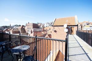 a balcony with tables and chairs and a view of a city at Harbour Penthouse Whitby in Whitby