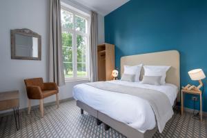 a bedroom with a large bed with a blue wall at Domaine du Béron - Chateau et gites in Cappelle-en-Pévèle