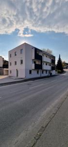 a white building on the side of a street at S3 Stadl Paura in Stadl-Paura