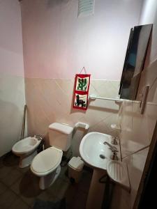 a bathroom with two toilets and a sink at Kantuta Hospedaje in Tilcara