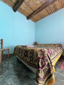 a bedroom with a bed in a blue wall at Kantuta Hospedaje in Tilcara
