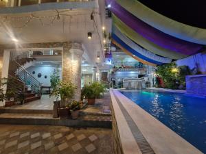 a large swimming pool in a building with plants at Aquatico Royalle Private Resort in Calamba