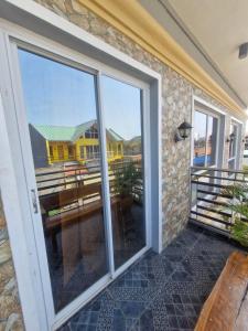 a screened in porch with a view of a house at Aquatico Royalle Private Resort in Calamba