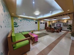 a living room with a green couch and a table at Aquatico Royalle Private Resort in Calamba