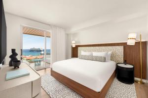 a bedroom with a bed and a view of the ocean at ONE GT Grand Cayman in George Town +90 photos