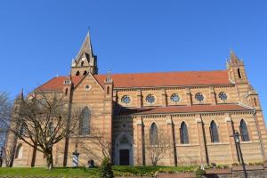 a large brick church with a tower on top of it at Appartement proche Eurexpo Aéroport Genas Centre in Genas