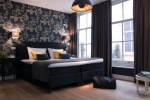a bedroom with a bed in a room with a window at Grand Canal Boutique Hotel in Amsterdam