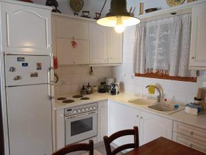 a kitchen with white cabinets and a white refrigerator at Maria Apostolou villa in Almiros +10 photos