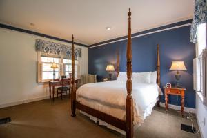 a bedroom with a bed and a blue wall at Beaumont Inn in Harrodsburg
