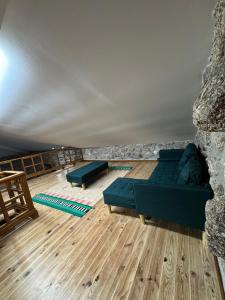 a living room with two blue couches and wooden floors at Casa D'Avó Carmen in Ventosa