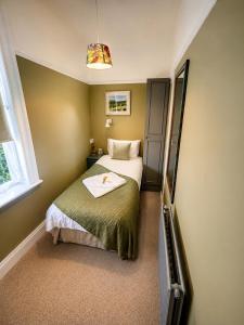 a small bedroom with a bed and a mirror at The Beaumont in Sittingbourne