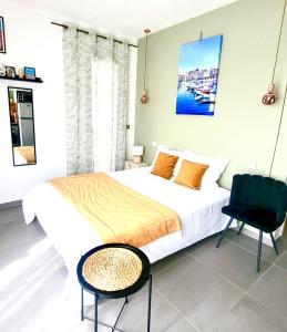 a bedroom with a large bed and a chair at Sous le figuier in Marseille